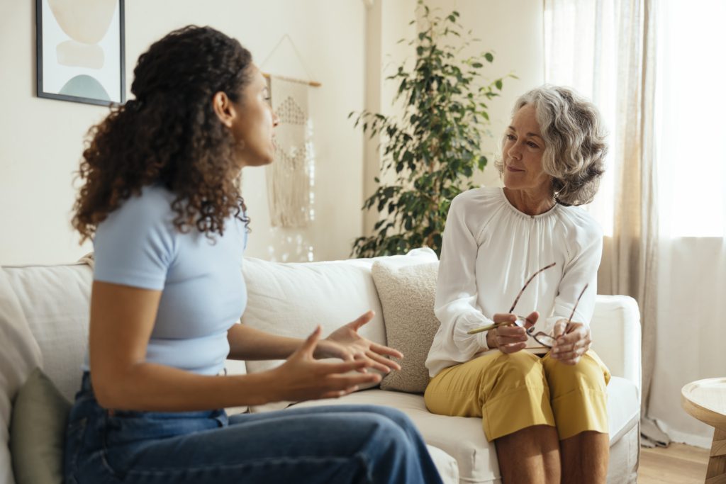 A woman explains her mental health challenges to her psychiatrist, an older woman.