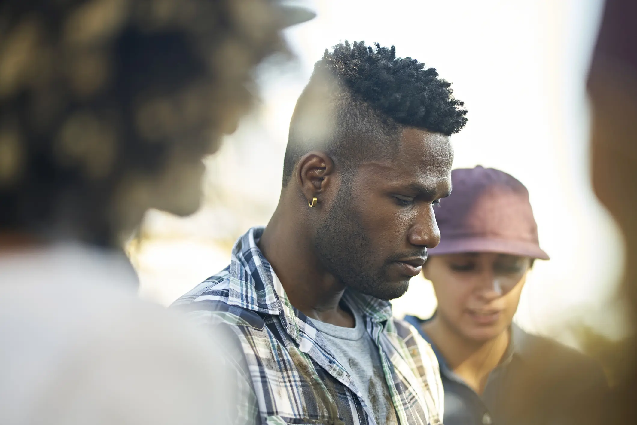 Depressed man looks downcast while participating in group therapy.
